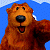 A pixelated cartoon bear mascot with brown fur and a black nose stands against a blue sky background, next to green text reading "Original Icons .com" on a dark green backdrop.