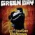 Pixelated image with 'GREEN DAY' text above a figure in dark clothing against warm-toned background.