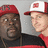 Two people wearing red caps with white brims stand side-by-side against a gray background, with red text reading 'DO WORK!' on the right.
