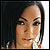 Static pixelated image of a person's face with dark hair and neutral expression against a gradient background.