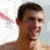 A pixelated image of a shirtless man with short dark hair smiling, positioned next to pink text reading "I Luv Michael" on a white background.