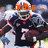 Pixelated image of a football player in dark uniform with number 7, wearing helmet and shoulder pads, standing on field.