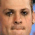 Pixelated close-up of a person's face showing eyes, nose, mouth, and partial ear with light skin tone and brown eyebrows.