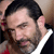 Static 50x50 pixel icon showing a close-up of a man's face with dark hair, beard stubble, and visible ear, wearing a white shirt collar against a blurred background.