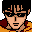 Pixelated character with black hair, light skin, and dark red clothing against orange and gray background.