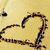 A heart drawn with brown lines on a beige background, surrounded by colorful pixelated hearts in various colors.