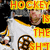 A hockey player in a white jersey with a black and yellow trim and a circular logo on the chest, with overlaid yellow text reading "HOCKEY IS THE SHIT".