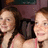 Two people with light skin tones and brown hair stand side-by-side in a pixelated image with a dark background.