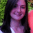 Pixelated close-up of a person with long dark hair, wearing a light-colored top, against a green and pink background.