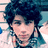 A pixelated image of a person with dark curly hair wearing a light-colored shirt with a patterned collar, shown in three views with slight variations in head position.