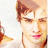 A pixelated image of a person with light brown hair and pink lips, partially obscured by red text on black bars.