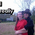 A pixelated image of two people embracing outdoors, with text overlays changing across frames.
