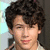 A pixelated image of a person with curly dark hair on the left, next to green text on a black background reading "I love nick jonas".