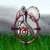 Pixelated static image shows a red circular frame with a central spiral pattern, set against a green grassy foreground and gray sky background with scattered blue and cyan dots.