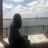 Pixelated static image shows a dark silhouette of a person standing near a railing with a blurred background of sky and water.