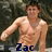 Pixelated image of a shirtless man with short brown hair standing against a dark background, with blue text reading "Zac" at the bottom.