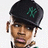 Pixelated image of a person wearing a black cap with green NY logo, next to green background with pink text.