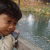 A child in a light-colored jacket with dark straps stands near water, expression shifting from neutral to smiling across frames.