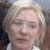 Static pixelated image of a person with light-colored hair, closed eyes, and a neutral expression, wearing a light-colored shirt against a blurred background.