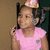 A child in a pink shirt and party hat holds a phone, with background changes across frames.