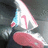 A pixelated static image shows a stylized figure with pink and white tones against a dark background, featuring a prominent curved shape at the bottom.