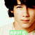 A static image of a person with dark curly hair wearing a light-colored shirt, overlaid with multiple green and pink text labels in various positions.