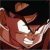 Pixelated image of a figure in a red outfit with white accents, holding a glowing white object against a dark background.