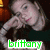 A pixelated image of a person with long hair resting their head on one hand, overlaid with green text reading 'brittany' and surrounded by colorful floral patterns.