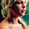 A close-up of a person with blonde hair and red lipstick, wearing a strapless top, with text overlay reading 'I'M READY' in white capital letters.