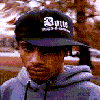 A person wearing a black cap with white text and a gray hoodie appears in a of , with yellow and orange pixelated overlays changing across observations