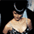 Pixelated static image of a shirtless person with dark hair and facial features against a black background, showing partial upper body and arms in a slightly angled pose.