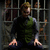 A pixelated character in a green vest and gray sleeves stands behind metal bars, hands pressed against the with shifting facial expression