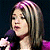 A split-frame contact sheet showing a woman with blonde hair holding a microphone on the left and green pixelated text reading "Original Icons .com" on the right against a dark background.