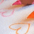 Pixelated image of two stylized figures with flowing hair against a light background, one in pink and brown tones, the other in orange and beige.