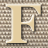 A static pixelated image of a large beige letter H with white outlines against a brown and gray checkered background.