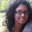 A person with curly dark hair and glasses appears in a of four , each showing slight variations in facial expression and head position against an outdoor background