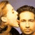 A 50x50 pixel animated buddy icon featuring a cartoon couple kissing on the left and green text "Original Icons .com" on the right, displayed as a contact sheet with two frames.