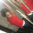 Pixelated image of a person in a red sleeveless top and dark pants lying on a gray surface with red and white elements in the background.