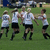 Four pixelated figures in white jerseys and black shorts on a green field, with text reading "soccer girls kick grass!" to the right.