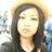 Pixelated image of a person with long dark hair wearing a light-colored hat and dark clothing against a blurred background.