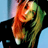 Pixelated static image of a person with long hair wearing dark clothing against a light blue background, showing visible dithering and color blending artifacts.