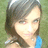 A pixelated image of a person with shoulder-length dark hair wearing a blue top, set against a green background.