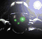 Animated sequence of a dark helmeted figure with glowing green eyes and three small dots on the face, emitting red laser beams from its mouth against a bright background.
