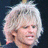 Static pixelated image of a person with light-colored curly hair, closed eyes, and visible facial features against dark background.