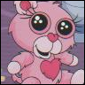 Pink cartoon character with large green eyes, red nose, and white whiskers holding a red heart, wearing a pink flower with red center on head.