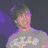 Pixelated image of a person with short gray hair wearing a light gray shirt against a purple background.