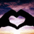 A heart-shaped icon with a gradient fill of white and purple hues, set against a dark background with a pinkish-purple sky and light-colored ground below.