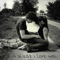 Black-and-white static image of two people embracing on a road with text at the bottom reading "I SWEAR I LOVE YOU".