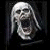 Pixelated grayscale image of a skeletal figure with long hair against dark background, next to green text reading Original Icons .com.