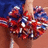 A person in a blue top holds red, white, and blue pom-poms with the word 'Cheer' visible above them.